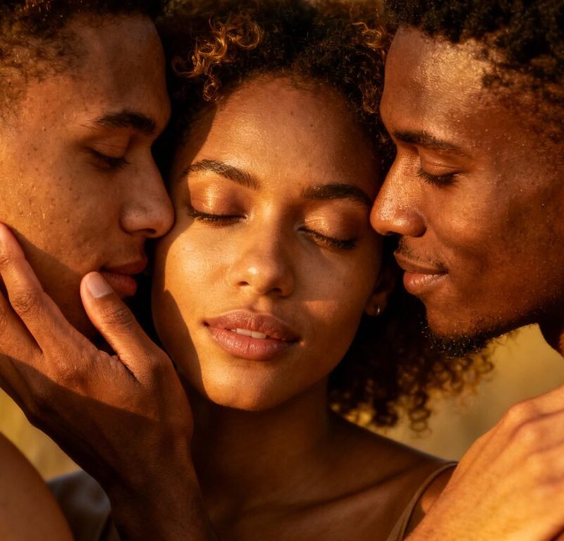 Three people in an affectionate embrace.
