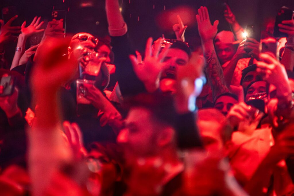 a crowd of people holding up their cell phones