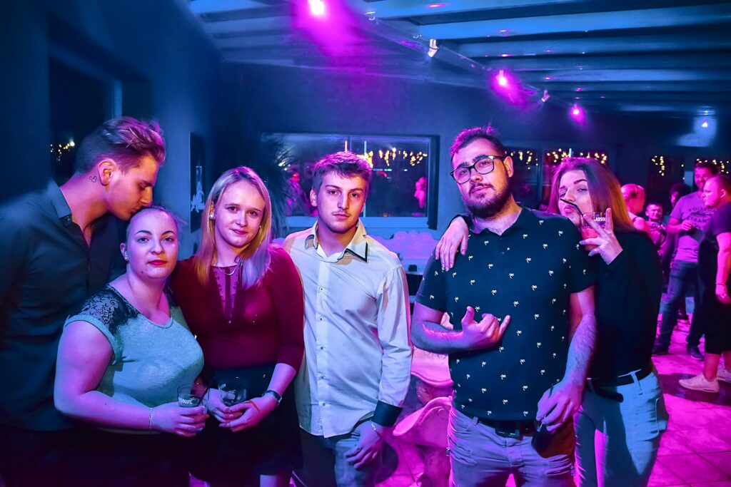 group of friends posing at a dimly lit party
