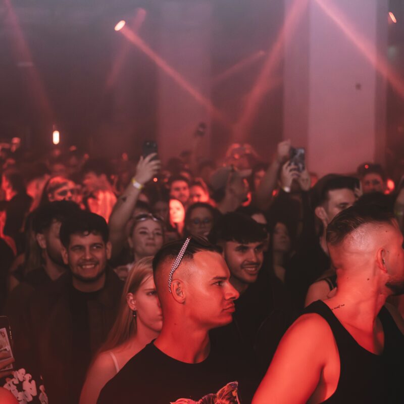 crowd enjoying a concert with red stage lights