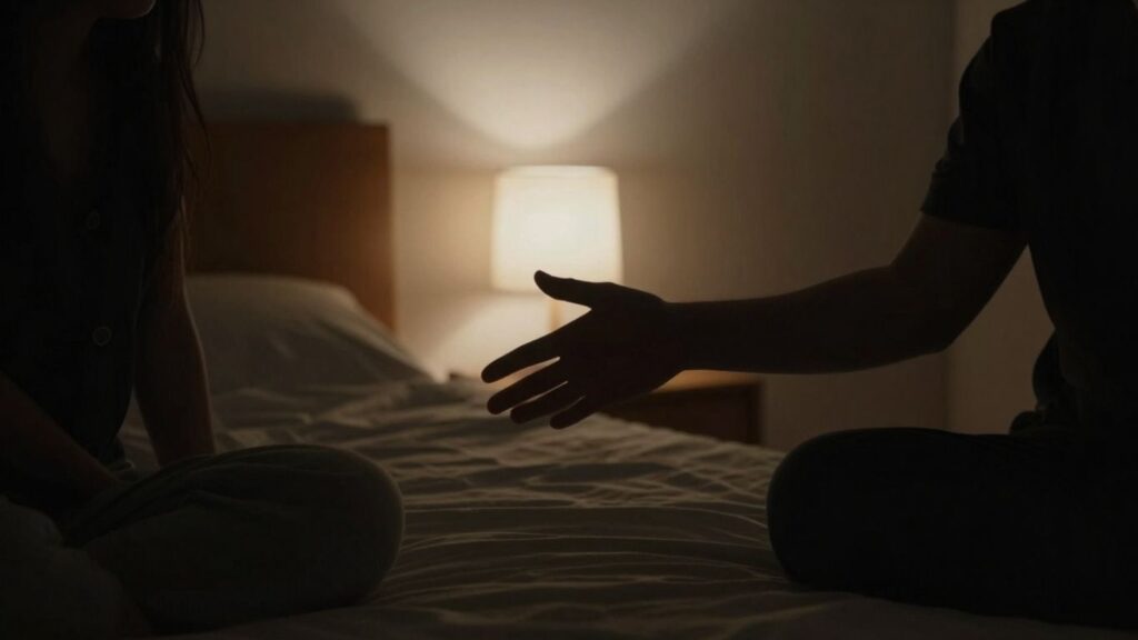 Couple in a dimly lit room, hands reaching.