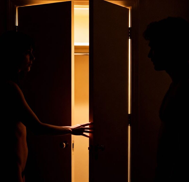 Couple in a dimly lit room near a closet.