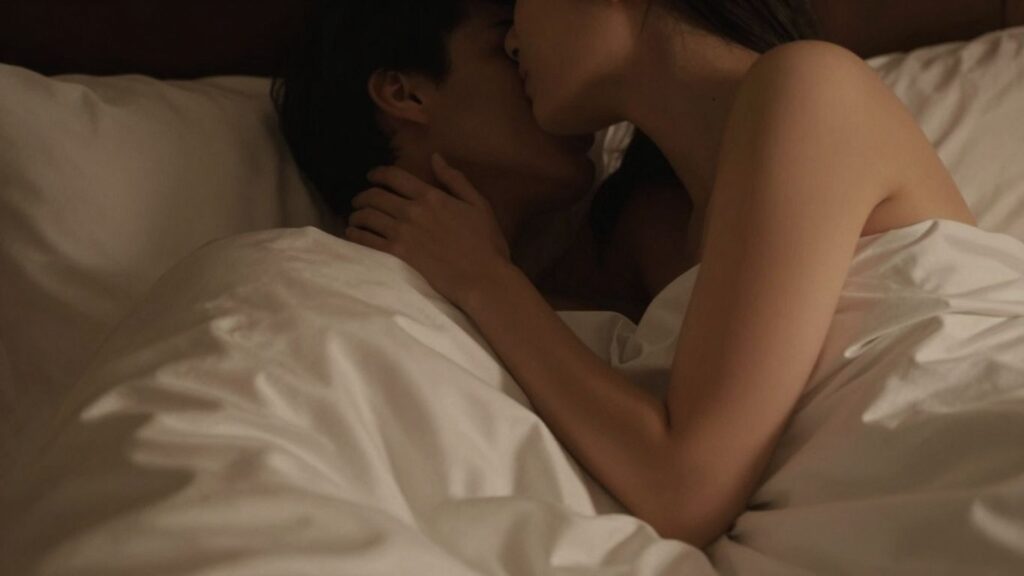 Couple in intimate setting, soft lighting, silk sheets.