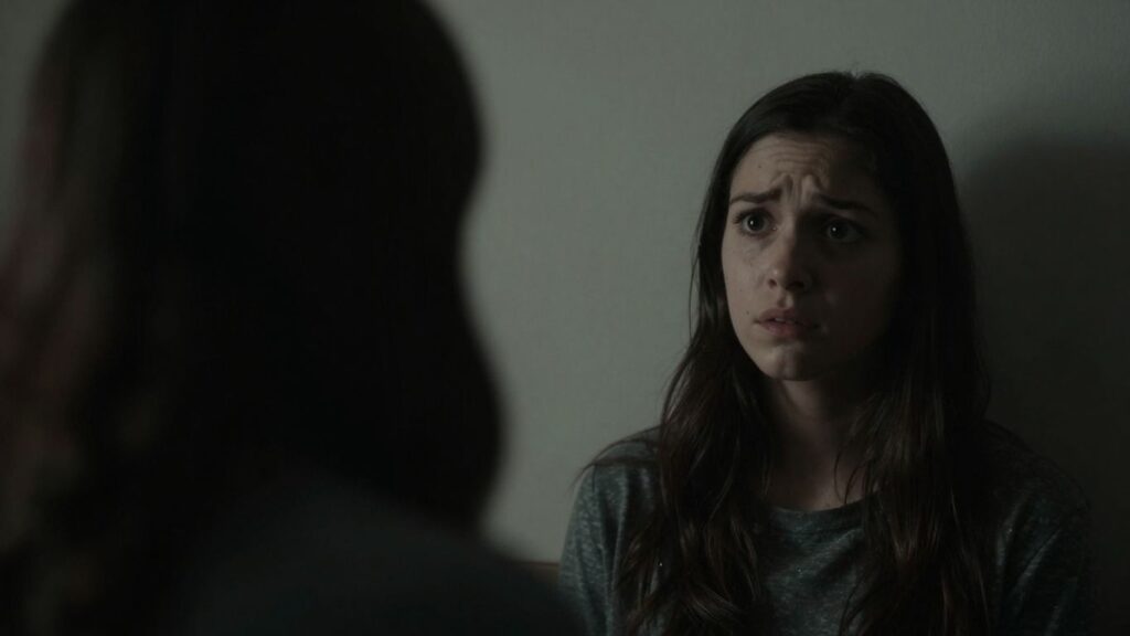 Couple in shadows, one looking back fearfully.