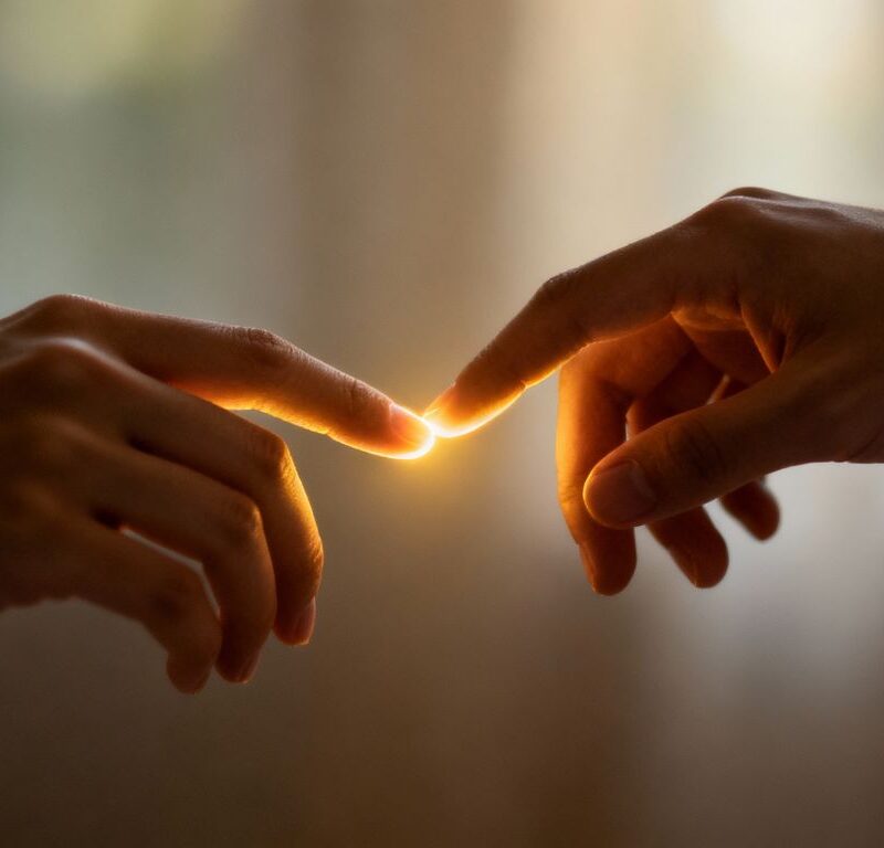 Hands touching with a soft glow, digital foreplay concept.