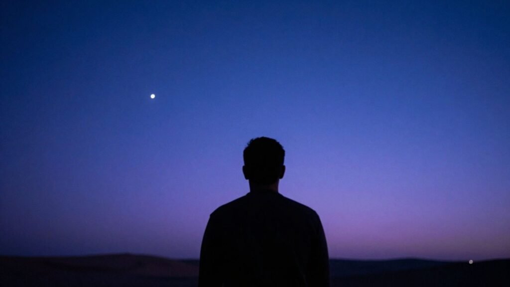 Man looking at a starry night sky, symbolizing self-discovery.
