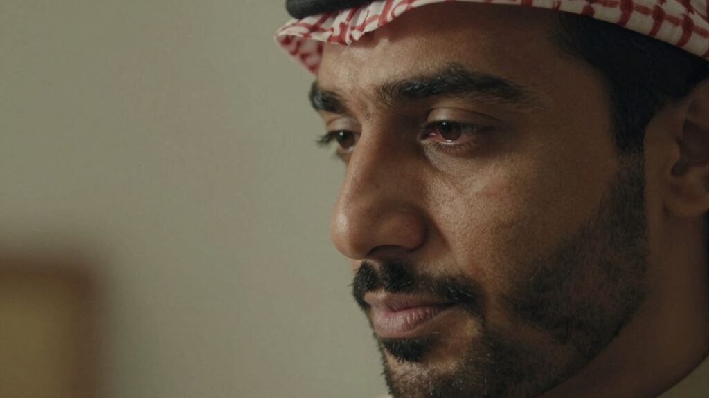 Man's thoughtful face in soft, intimate lighting.