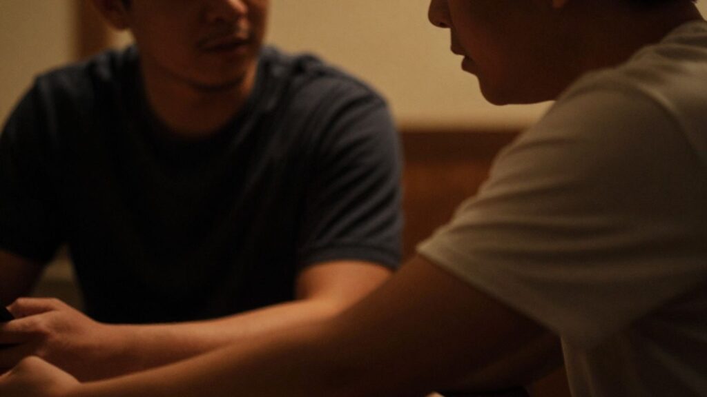 Two men in an intimate, dimly lit setting.