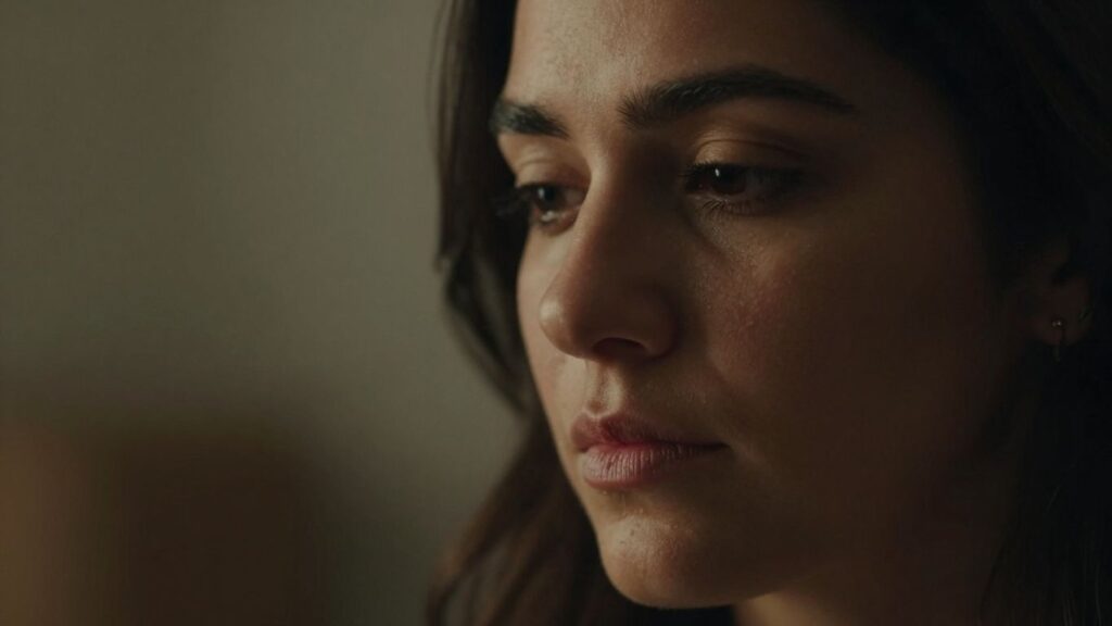 Woman's face in soft light, thoughtful expression.