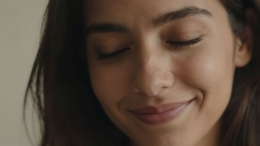 Woman's face with a subtle smile, conveying intimacy and trust.