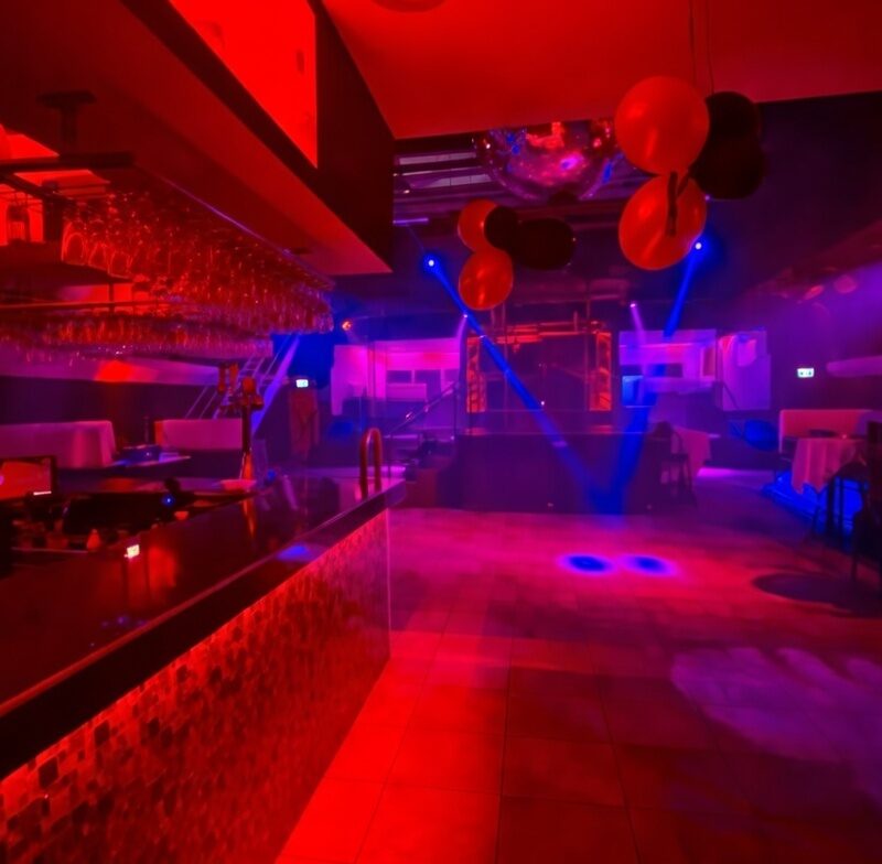 Interior of Luxuria Montréal nightclub with intense red and purple lighting
